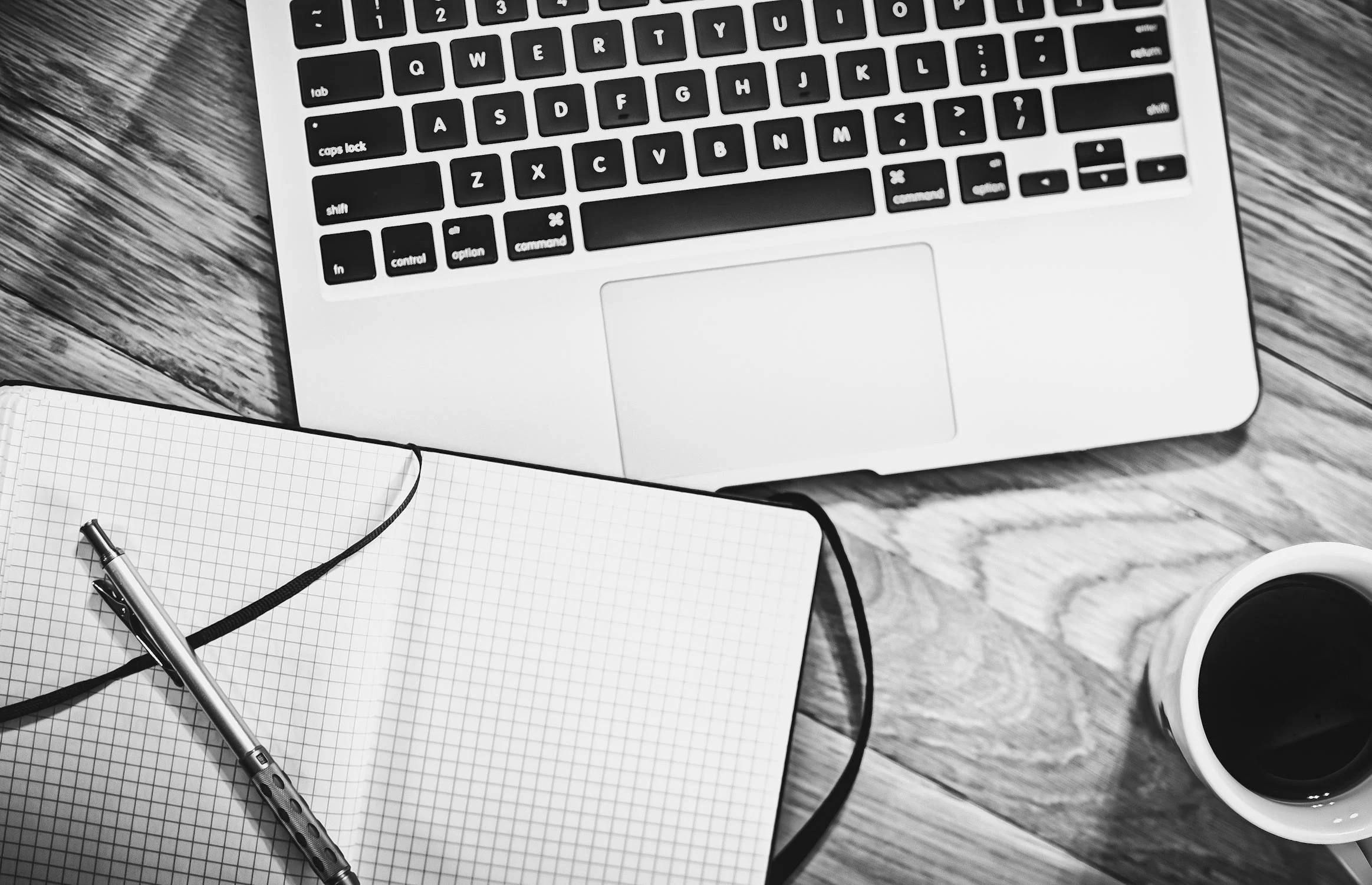 a laptop and books on a table in black Advertising and Marketing Agency in Dubai and white for contact